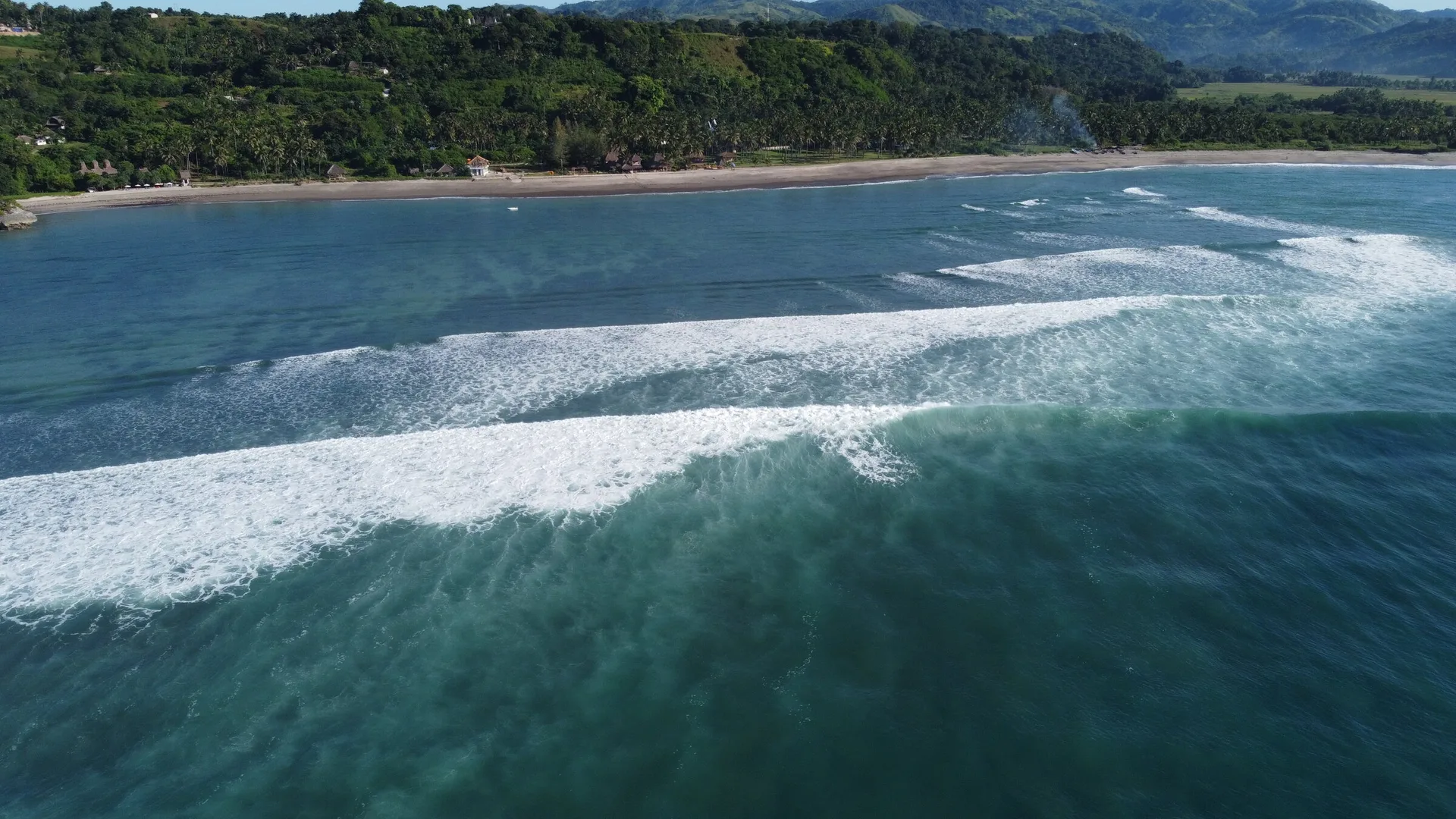 Aerial of the point break and turquoise reef, Pantai Kerewe